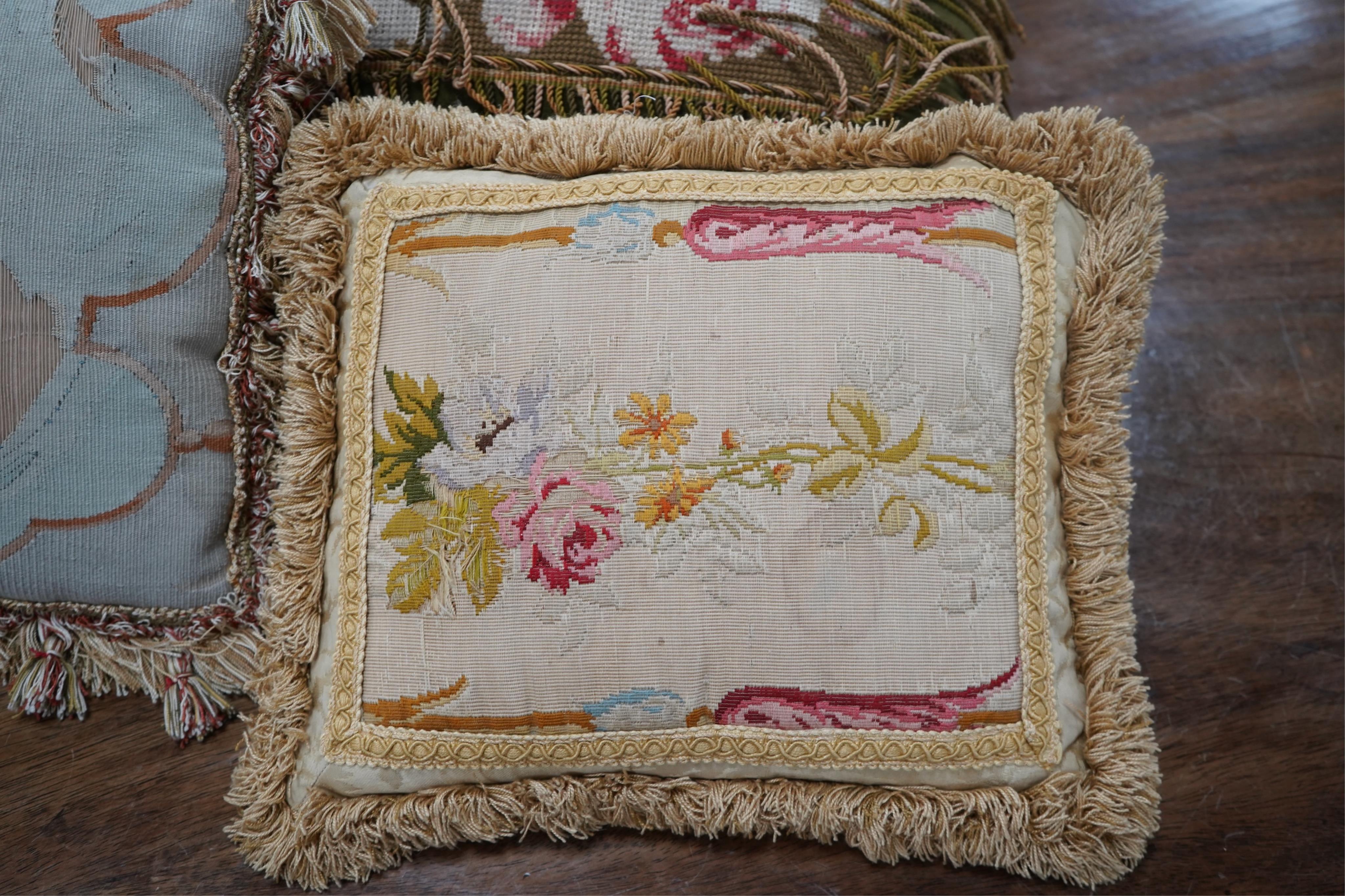 Seven 19th century cushions. Three Aubusson tapestry cushions and two machine Aubusson cushions, together with two floral wool worked cushions, all with decorative fringing. Largest 40cm x 45cm. condition - three are wor